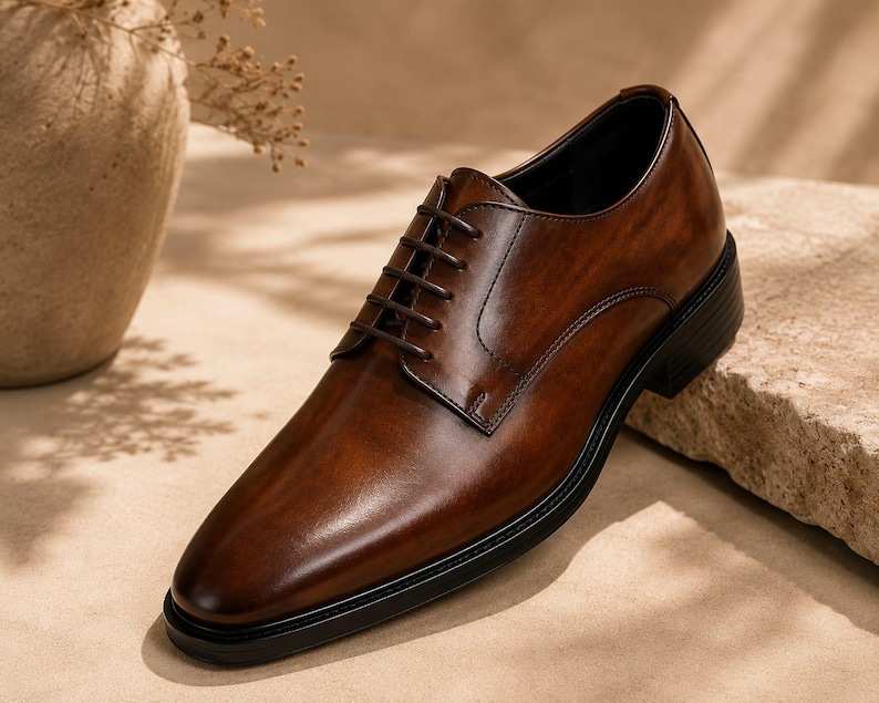 May include: A polished dark brown leather oxford shoe featuring a classic closed-lacing system, a rounded toe, and a solid black sole. The shoe displays a smooth, burnished finish with tonal stitching details along the eyelet panels and heel.