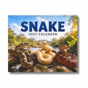 May include: A 2027 wall calendar titled SNAKE 2027 CALENDAR featuring a spiral binding at the top. The cover displays three snakes resting on a mossy log near a river: a yellow and black patterned snake, a solid yellow snake, and a red and black snake.