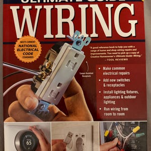 May include: A book titled Ultimate Guide Wiring Updated 10th Edition by Creative Homeowner. The cover features a white electrical receptacle, a smart thermostat, a USB wall charger, and various electrical wires with colored wire nuts.
