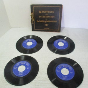 May include: Four black vinyl records with blue labels are arranged around a dark brown book. The book is titled "The Proverbs, Ecclesiastes, The Song of Solomon." The records have white text and a blue center.