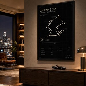 May include: A framed black and white print of the Laguna Seca racetrack in Monterey, California, USA. The track map is displayed with key features and specifications, including length (3602 km), turns (11), and elevation (55 m).