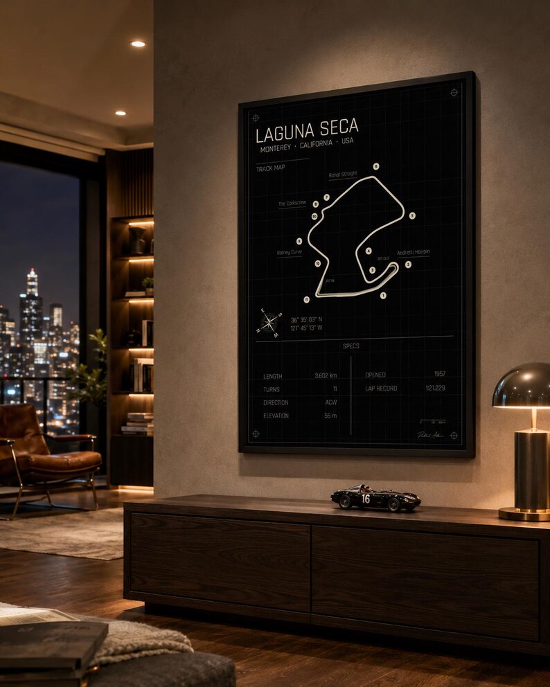 May include: A framed black and white print of the Laguna Seca racetrack in Monterey, California, USA. The track map is displayed with key features and specifications, including length (3602 km), turns (11), and elevation (55 m).