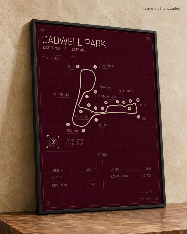 K&ouml;nnte beinhalten: Gerahmter Cadwell Park Streckenkarten-Druck. Der bordeauxfarbene Druck zeigt einen wei&szlig;en Streckenverlauf mit beschrifteten Kurven und einer Windrose. Die Karte enth&auml;lt eine Streckenl&auml;nge von 3,49 km, 18 Kurven und wurde 1938 er&ouml;ffnet.