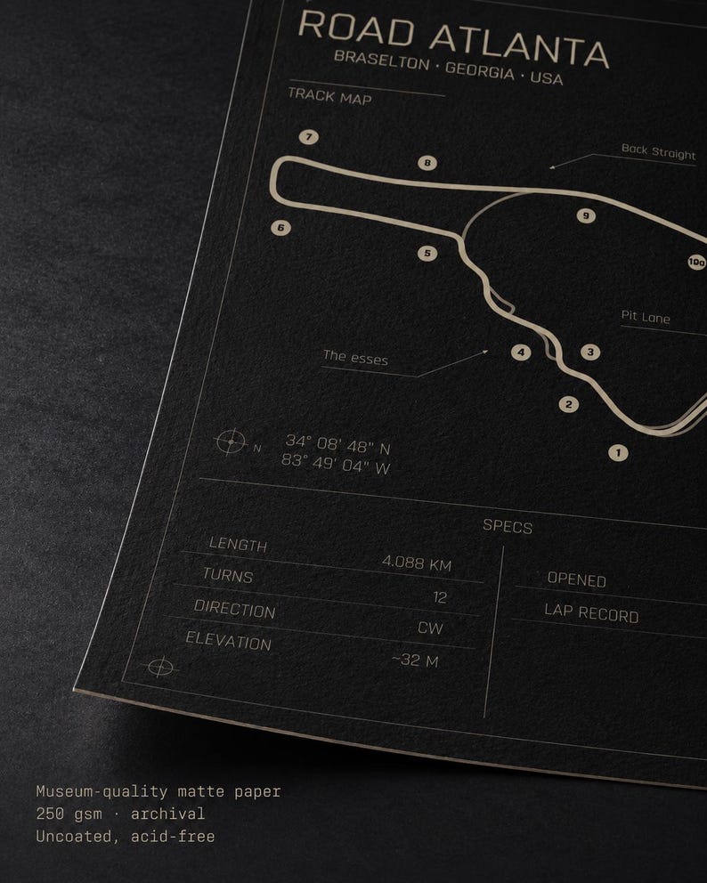 May include: A black and white print of the Road Atlanta track map, located in Braselton, Georgia, USA. The print includes track specifications such as length (4.088 km), turns (12), and elevation (-32 m). The text "ROAD ATLANTA" is at the top.