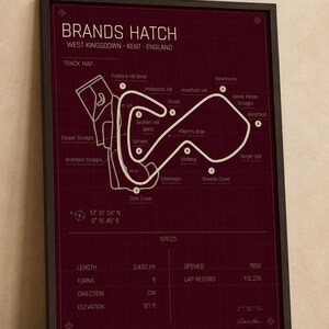 May include: Framed print of the Brands Hatch race track in West Kingsdown, Kent, England. The track map is in white on a dark red background. Includes track specs: 2.433 miles, 9 turns, and opened in 1950. The elevation is 121 ft.