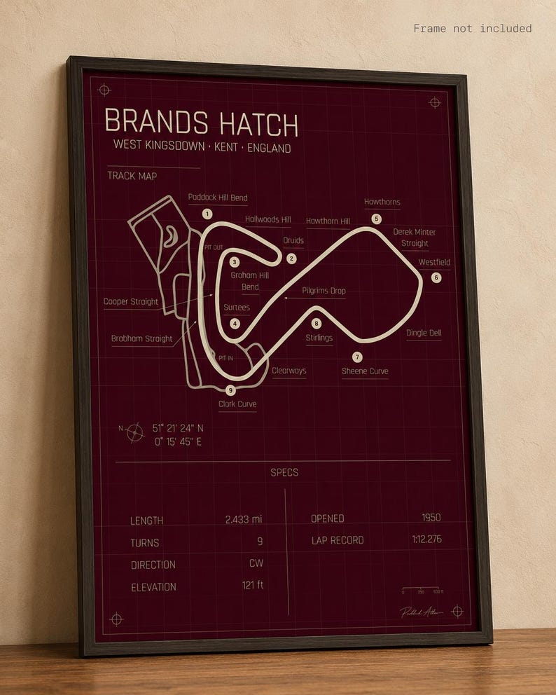 May include: Framed print of the Brands Hatch race track in West Kingsdown, Kent, England. The track map is in white on a dark red background. Includes track specs: 2.433 miles, 9 turns, and opened in 1950. The elevation is 121 ft.