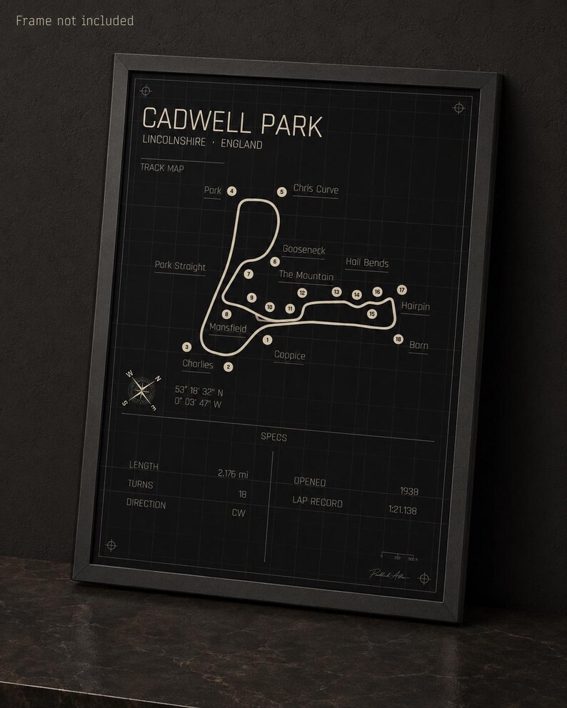 K&ouml;nnte beinhalten: Schwarz gerahmter Druck der Rennstrecke Cadwell Park in Lincolnshire, England. Die Streckenkarte ist wei&szlig; auf schwarzem Hintergrund, mit beschrifteten Kurven und Spezifikationen. Die Streckenl&auml;nge betr&auml;gt 3,5 km. Enth&auml;lt die Koordinaten der Strecke.
