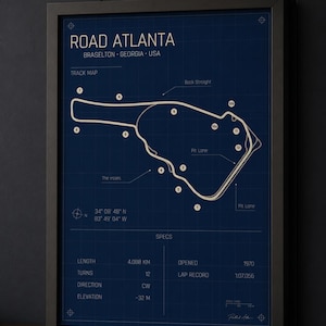 May include: Framed blueprint-style print of the Road Atlanta racetrack in Braselton, Georgia, USA. The track map is white on a dark blue background, with specs including length (4.088 km), turns (12), and opening year (1970).