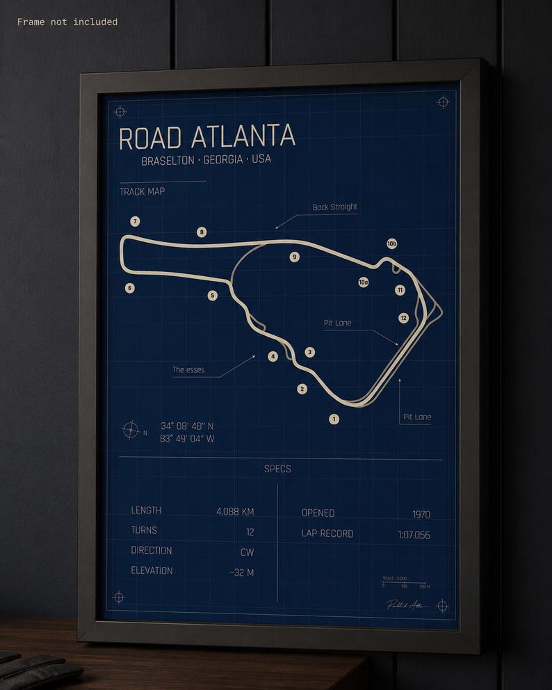 May include: Framed blueprint-style print of the Road Atlanta racetrack in Braselton, Georgia, USA. The track map is white on a dark blue background, with specs including length (4.088 km), turns (12), and opening year (1970).