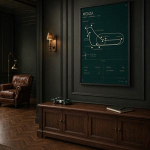 Op de afbeelding: Een ingelijste racekaart van het Monza circuit in Itali&euml;, op een donkergroene achtergrond. De witte kaart toont de baanindeling en details. Daaronder een donkerhouten kast met modelauto en boek. Donkere muren en een leren fauteuil.