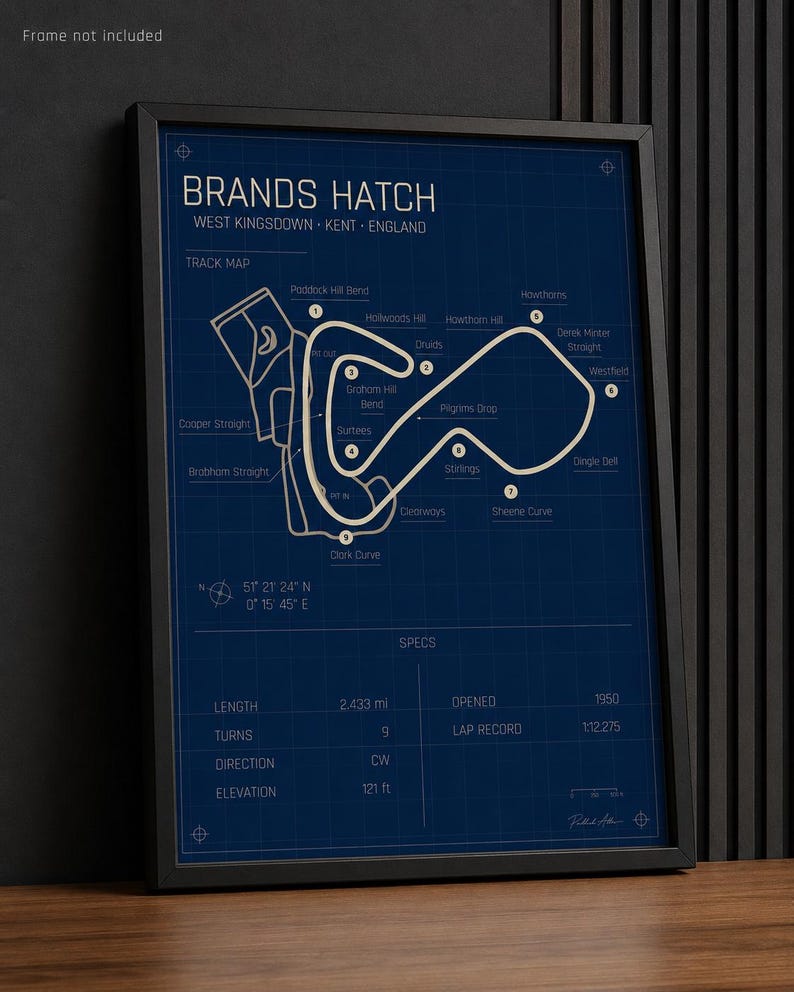 May include: Framed Brands Hatch track map print. The blueprint-style design features the track layout, labeled turns, and specifications. The print includes the track's length of 2.433 miles and elevation of 121 feet.