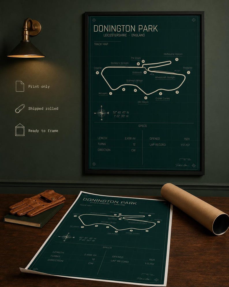 Op de afbeelding: Een ingelijste Donington Park circuitkaart print in donkergroen, met witte details. De print bevat circuitspecificaties en is klaar om in te lijsten. Een tweede print en een opgerolde koker zijn ook zichtbaar.