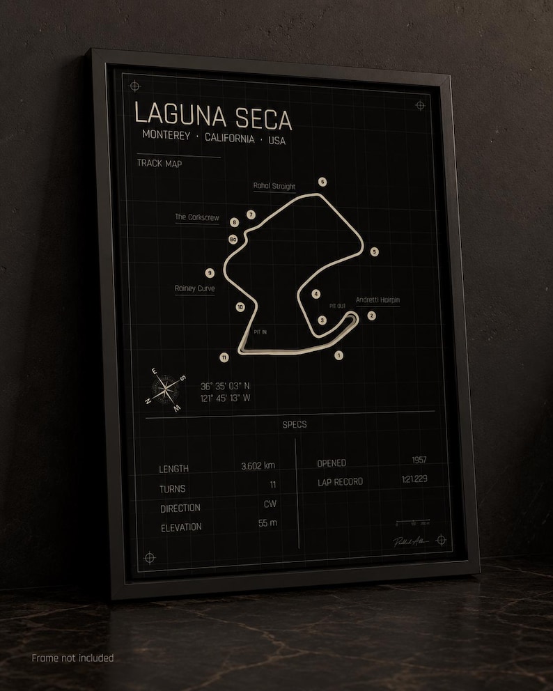 May include: Black framed print of the Laguna Seca racetrack in Monterey, California. The track map is white on a black background, with labeled turns and specs including length (3.602 km), turns (11), and elevation (55 m).