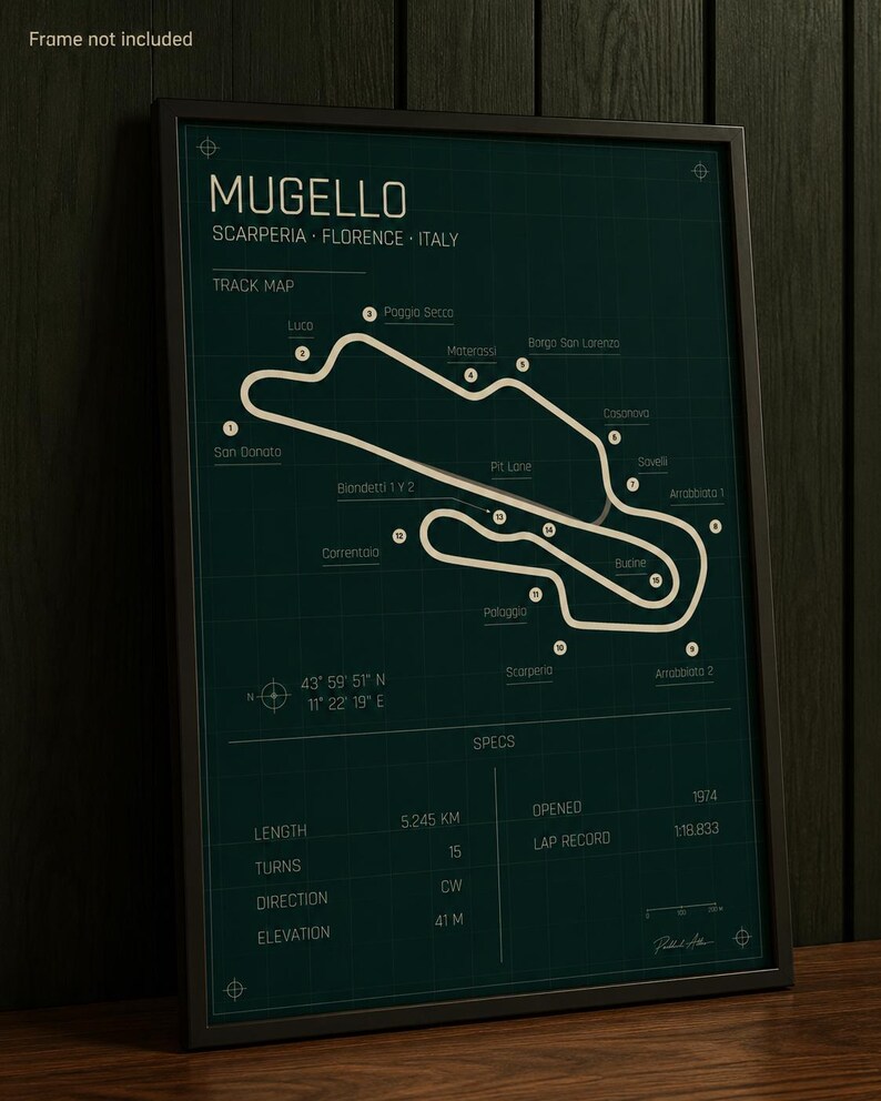 May include: Framed Mugello track map poster. The dark green poster features a white track layout with labeled turns and locations. Includes specs: 5.245 km length, 15 turns, and 41 m elevation. The poster is in a black frame.