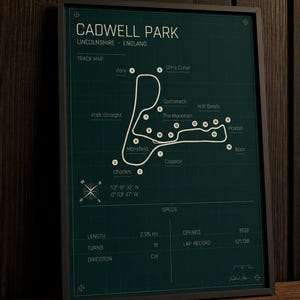 K&ouml;nnte beinhalten: Gerahmter Druck der Rennstrecke Cadwell Park in Lincolnshire, England. Die wei&szlig;e Streckenkarte vor dunkelgr&uuml;nem Hintergrund zeigt Kurvenbezeichnungen und eine Windrose. Die Spezifikationen der Strecke sind: 3,5 km, 18 Kurven, Er&ouml;ffnung 1938.