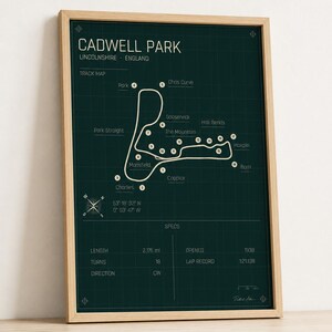 Puede incluir: Un póster de color verde oscuro que muestra un mapa técnico del circuito de carreras Cadwell Park en Lincolnshire, Inglaterra. El diseño incluye una cuadrícula blanca, el trazado con curvas numeradas, coordenadas geográficas y especificaciones técnicas.