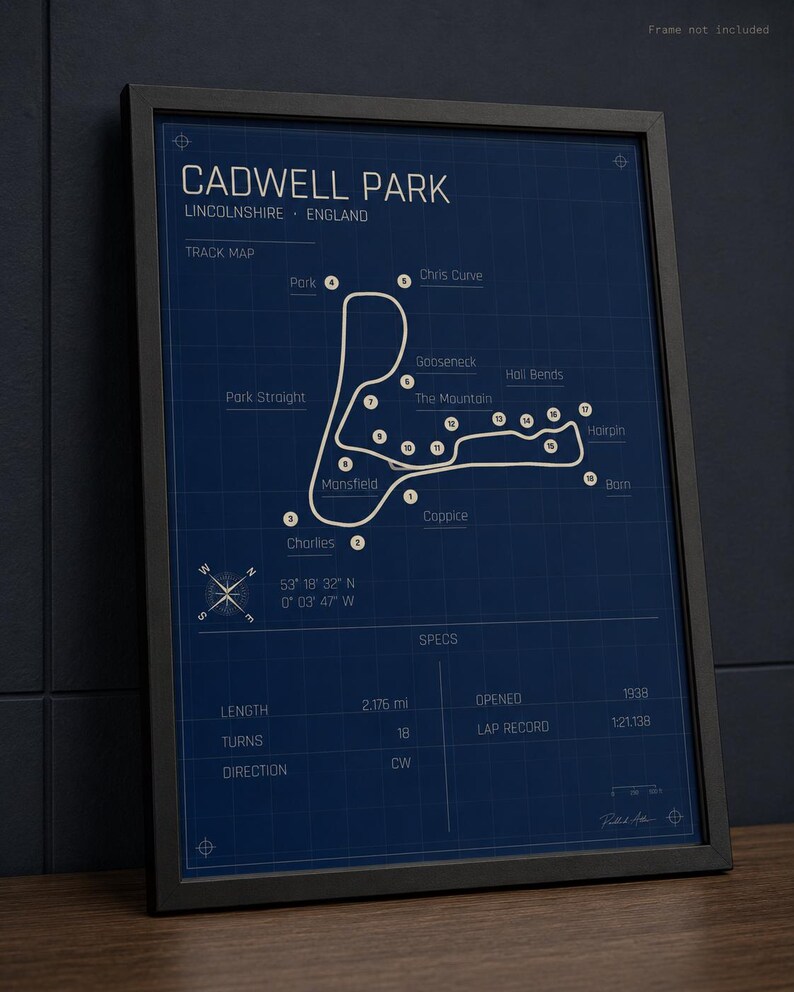 K&ouml;nnte beinhalten: Gerahmter Druck der Rennstrecke Cadwell Park in Lincolnshire, England. Die Streckenkarte ist wei&szlig; auf dunkelblauem Hintergrund, mit Beschriftungen f&uuml;r Kurven und Merkmale. Der Druck enth&auml;lt Spezifikationen wie L&auml;nge (3,5 km) und Er&ouml;ffnungsjahr (1938).