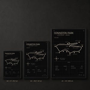 Op de afbeelding: Drie ingelijste zwart-wit prints van het Donington Park circuit in Leicestershire, Engeland. De prints zijn gelabeld A4 (21 x 29,7 cm), A3 (29,7 x 42 cm) en A2 (42 x 59,4 cm). Elke print bevat een circuitkaart en specificaties.