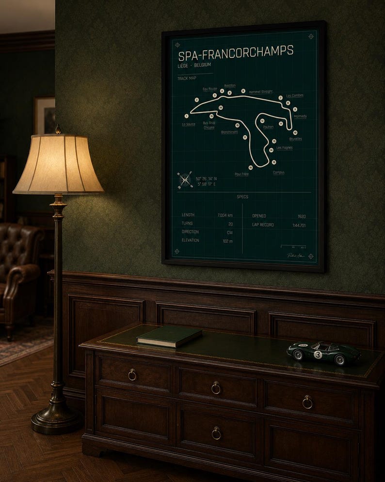 Pode incluir: Um poster emoldurado do mapa da pista de Spa-Francorchamps em verde escuro. O poster inclui detalhes e especifica&ccedil;&otilde;es da pista. Um carro de corrida verde e um livro est&atilde;o em um arm&aacute;rio de madeira. Uma lumin&aacute;ria de ch&atilde;o com uma abajur bege est&aacute; &agrave; esquerda.