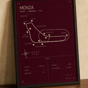 Op de afbeelding: Ingelijste print van het Monza-circuit in Itali&euml;, met een bordeauxrode achtergrond en witte circuitlijnen. De print bevat circuitdetails, co&ouml;rdinaten en specificaties zoals lengte (5,793 km), bochten (11) en ronderecord (1:20.901).