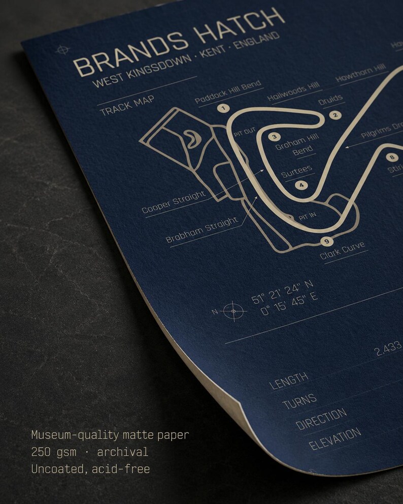 May include: A navy blue print of the Brands Hatch race track in West Kingsdown, Kent, England. The track map is in white, with labeled turns and straights. The print includes the text "BRANDS HATCH" and "TRACK MAP". The paper is museum-quality matte.