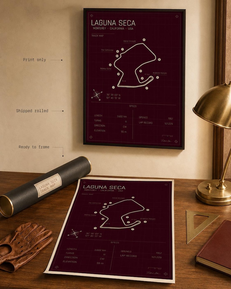 May include: A framed burgundy print of the Laguna Seca racetrack map. The print includes track details and specifications. A rolled print and a pair of driving gloves are on a wooden surface. The print is ready to frame.