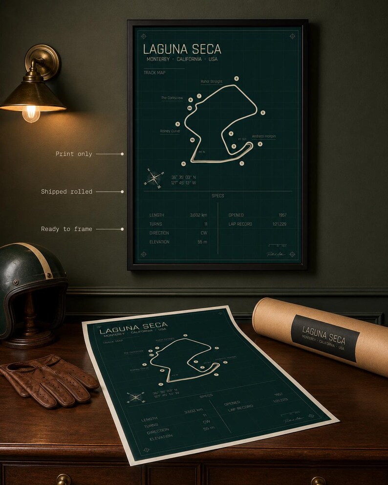 May include: A framed Laguna Seca race track map print in a dark green and white design. The print includes track details and is displayed with a rolled print and a vintage helmet and gloves.