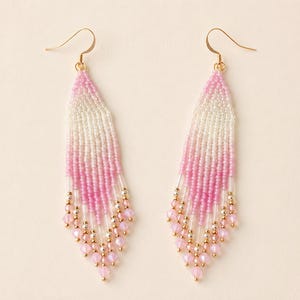 May include: A pair of beaded earrings with a gradient design. The earrings transition from white to pink, with gold-colored accents and pink crystal beads at the bottom. The earrings have gold-colored ear wires.