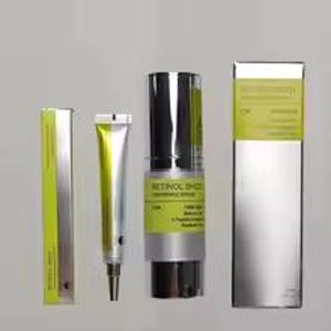 May include: A Retinol Shot skincare set featuring a silver and lime green tube, a matching silver and lime green pump bottle, and two corresponding rectangular silver and lime green boxes. The text on the packaging reads Retinol Shot.