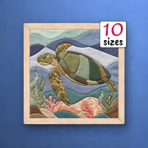 May include: A square fabric wall art piece in a light wood frame featuring a quilted sea turtle swimming over coral and seaweed. The background consists of blue and white fabric waves. A white label in the corner displays the text 10 sizes.