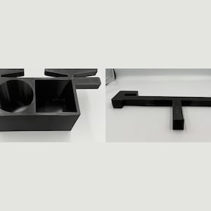 May include: A black plastic desk organizer featuring a circular cup holder and a square compartment. The unit includes a T-shaped support structure with extended arms on the sides, designed to sit securely on a flat surface for storage.