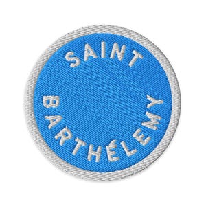 以下が含まれることがあります： 鮮やかなブルーの中央に白い文字でSAINT BARTHELEMYと円状に刺繍が施された円形の刺繍ワッペン。縁取りは白いステッチで仕上げられており、円形デザイン全体を囲んでいます。