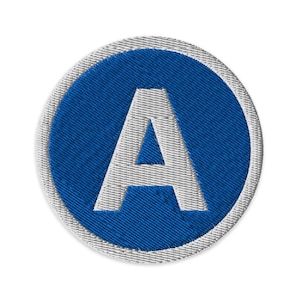 May include: Embroidered patch featuring the letter "A" in white, centered on a blue circular background. The patch has a textured appearance with a white stitched border, suitable for apparel or crafts.