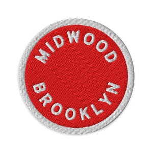 Peut inclure: Un écusson brodé circulaire présentant un centre rouge vif avec le texte blanc MIDWOOD BROOKLYN cousu en motif incurvé le long du périmètre. L'écusson est fini avec une bordure blanche nette cousue autour du bord extérieur.