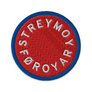 May include: Circular embroidered patch featuring the text "STREYMOYAR" in white on a red background, with a blue border. The patch is designed to be sewn onto clothing or accessories, and is circular in shape.