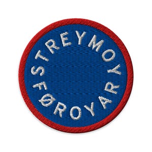 Puede incluir: Parche bordado circular con centro azul y borde rojo. El parche presenta texto blanco en un patrón circular que dice "STREYMOR FØR ROYA". El diseño es circular y tiene una apariencia texturizada.