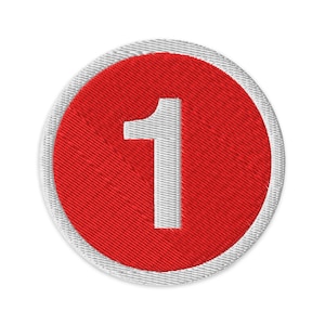 May include: Embroidered patch featuring the number 1 in white, centered on a red circle. The red circle is surrounded by a white border, creating a clean, simple design. The patch is likely for clothing or accessories.