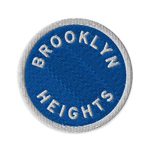 May include: Circular embroidered patch with a blue center and white text. The text reads "BROOKLYN HEIGHTS" in a circular pattern. The patch has a silver-gray border and is set against a white background.