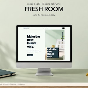 May include: A computer monitor displaying a website template titled Fresh Room with the text Make the next launch easy. The screen shows a clean layout with dark blue typography, a yellow mug, and a framed image on a light green background.