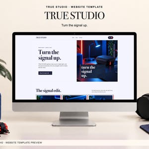 Può includere: Un monitor di computer mostra il modello di sito web True Studio con il testo Turn the signal up. Lo schermo presenta un layout pulito con un'immagine di prodotto a tema scuro, un menu di navigazione e una sezione intitolata The signal edit.