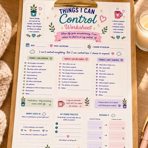 May include: A printed worksheet titled Things I Can Control with sections for self-reflection, including lists for things to control, influence, and release. The document features pastel illustrations of plants, mugs, and hearts, held by a gold metal clip.