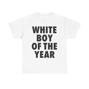 May include: White t-shirt with the text "WHITE BOY OF THE YEAR" in bold, black capital letters. The shirt is made of a soft, light-colored fabric.
