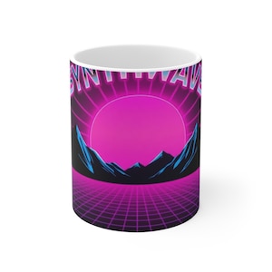 Op de afbeelding: Witte keramische mok met een retro design. De mok heeft het woord "SYNTHWAVE" in neonblauw en roze. Het ontwerp bevat een roze zon, blauwe bergen en een paars rasterpatroon, dat doet denken aan de jaren 80.