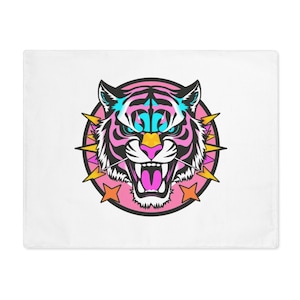 Op de afbeelding: Een witte kussensloop met een kleurrijk tijgerkopontwerp. De tijger heeft roze strepen, blauwe en gele accenten en een felle uitdrukking. Het ontwerp is omgeven door een roze cirkel en gele sterren.