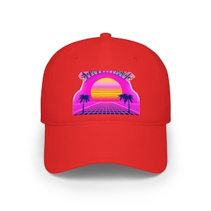 Puede incluir: Gorra de béisbol roja con un diseño retro "Synthwave". El gráfico incluye una puesta de sol, palmeras y un patrón de cuadrícula, todo en vibrantes tonos rosa, amarillo y morado. La gorra es de estilo clásico de seis paneles.