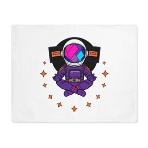 Op de afbeelding: Een witte kussensloop met een cartoon astronaut in een paars ruimtepak, helm met geometrische vormen en cassettes. De astronaut zit in een meditatieve pose, omringd door oranje sterren.