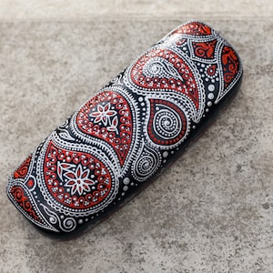 Eyeglass case for reading glasses, hand-painted with red and silver paisley design. View from the top