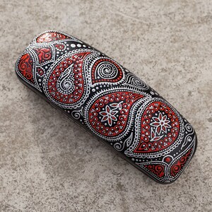 Eyeglass case for reading glasses, hand-painted with red and silver paisley design. View from the top