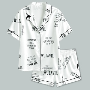 Könnte beinhalten: Ein weißes kurzärmeliges Pyjama-Set mit schwarzer Paspelierung und einem sich wiederholenden schwarzen Textdruck mit Phrasen wie Ew David, Stop acting like a disgruntled pelican, Love that journey for me und Best wishes, warm regards auf Oberteil und Shorts.
