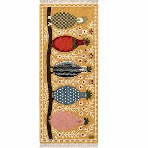 May include: A rectangular mustard yellow rug featuring a vertical dark brown branch with five stylized birds perched on it. The birds have distinct patterns including checkered, solid red, striped, blue polka dot, and solid pink, with white floral motifs.